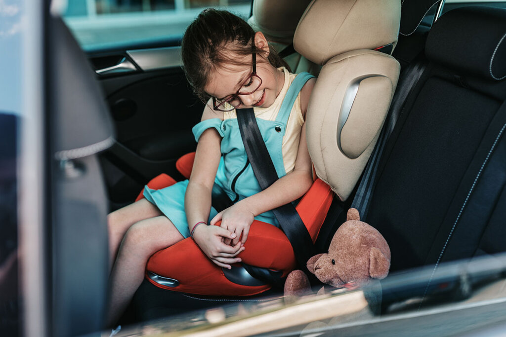 child_sitting_in_car_with_their_teddy_bear