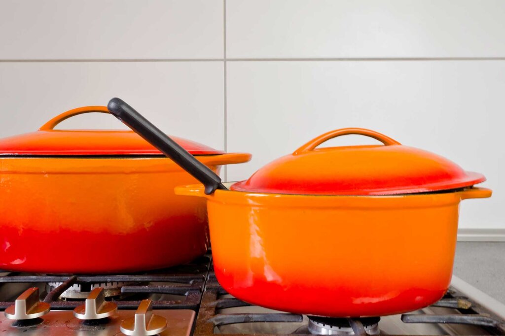 deux casseroles orange sont posées sur la cuisinière