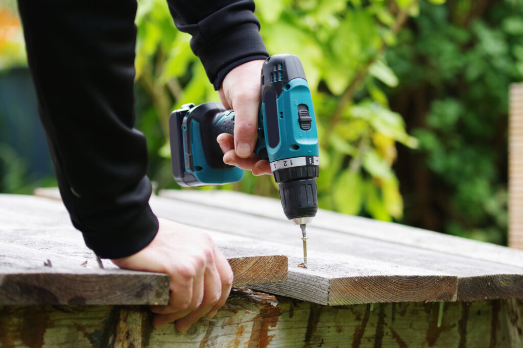 Une perceuse-visseuse sans fil perce du bois.