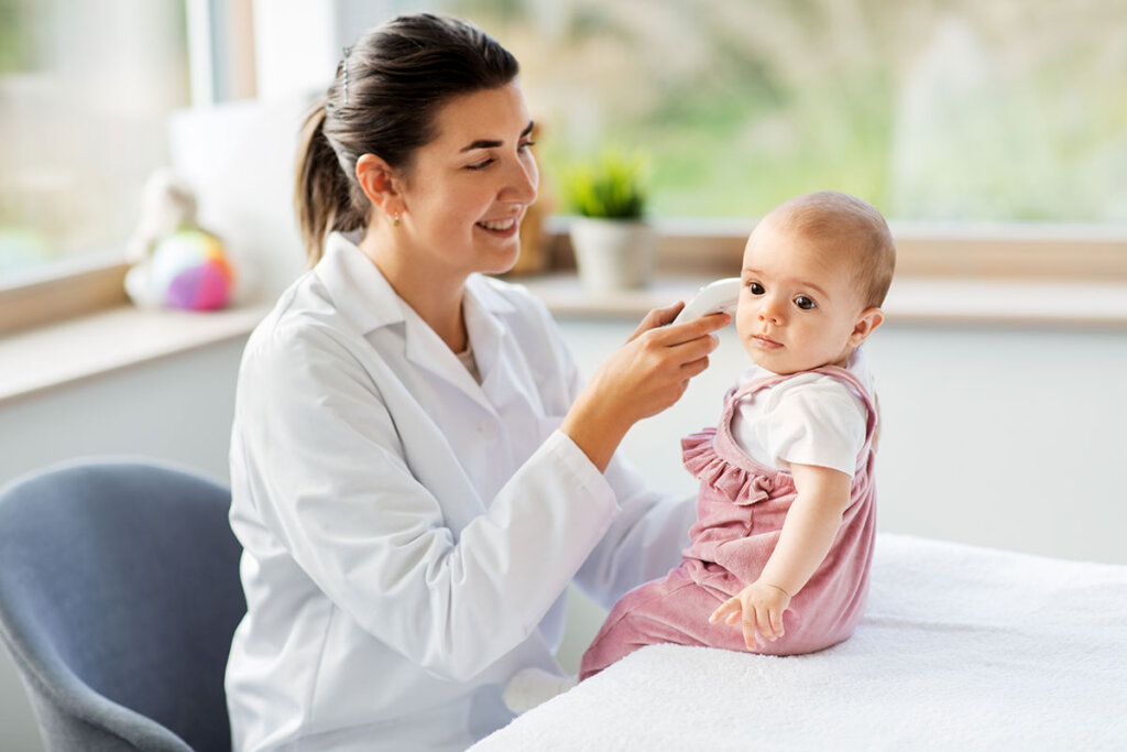 pédiatre prend la température d'un petit enfant