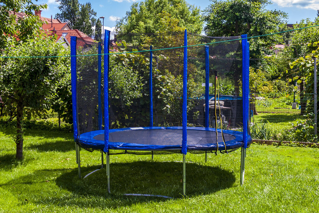 Grand trampoline bleu dans le jardin