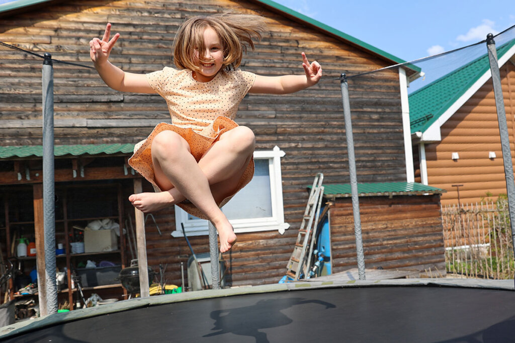 Les enfants sautent sur le trampoline de jardin