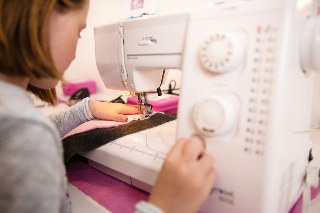 L'enfant coud un vêtement