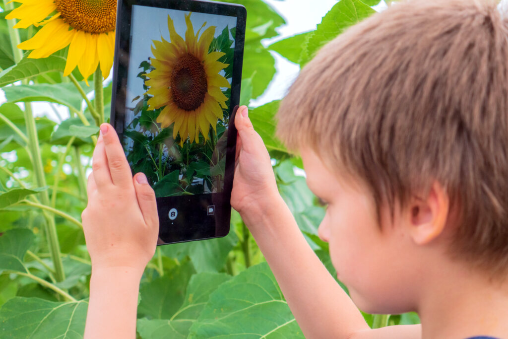 le garçon prend une photo avec la tablette