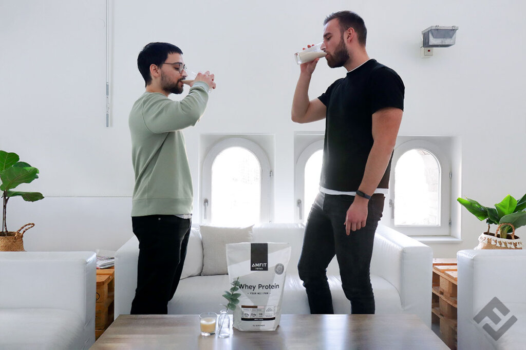 Two guys drink a shake of Amfit Nutrition Total whey powder Cookies and Cream.