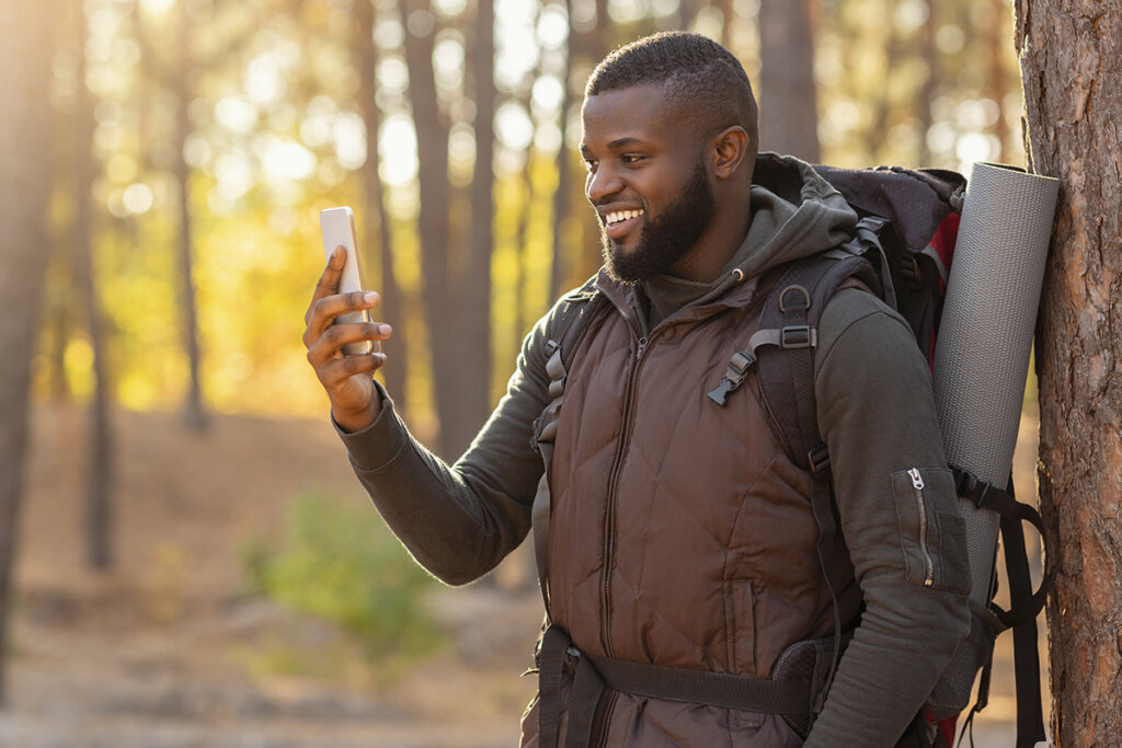 Homme dans la forêt regardant son smartphone