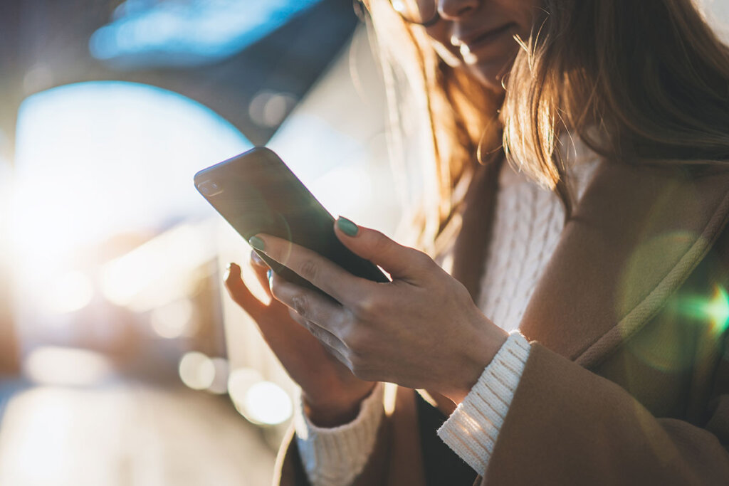 Femme tenant un smartphone à la gare