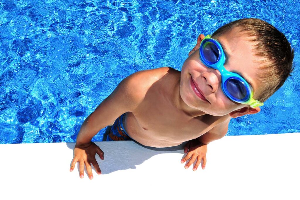 Enfant avec lunettes de natation sort de la piscine