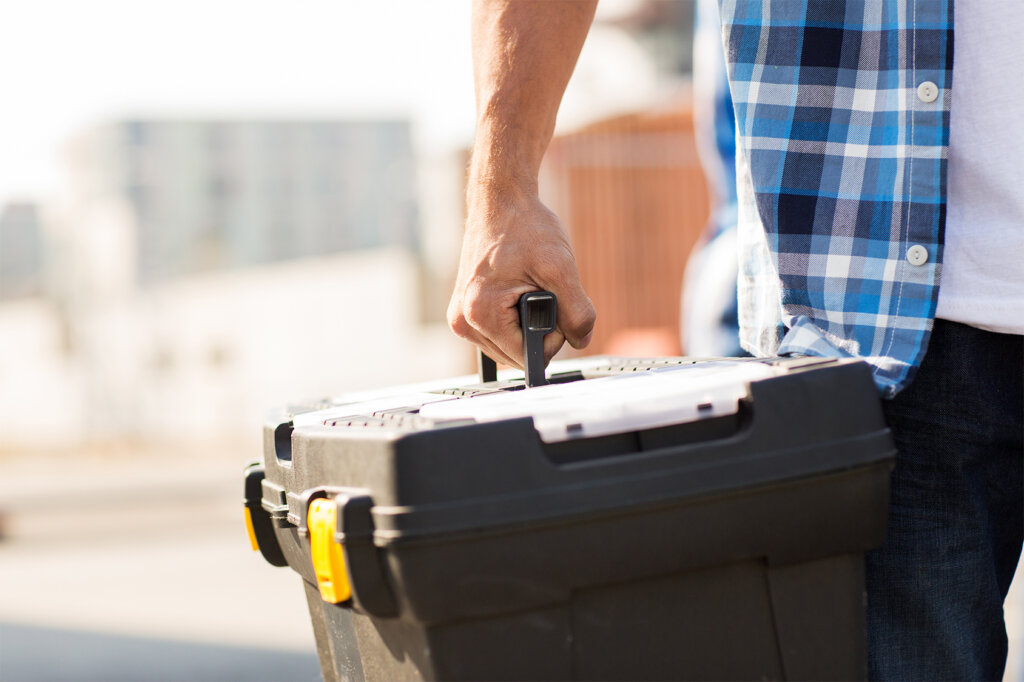 un homme porte une boîte à outils