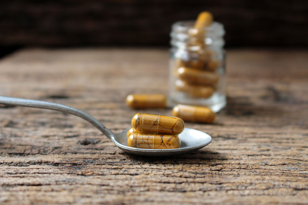 capsules de curcuma sur une cuillère